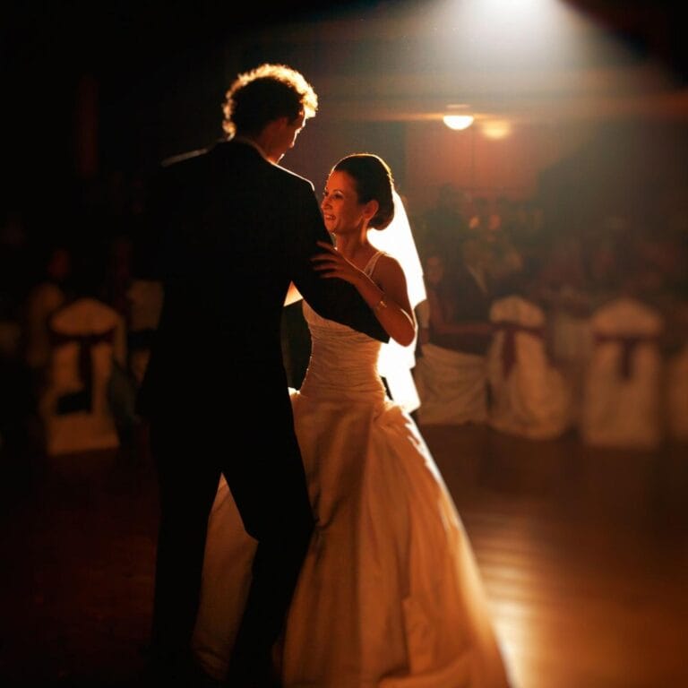 Bride and groom dancing their first dance with romantic lighting at wedding reception